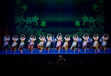 Na scenie Artyści w kostiumach pszczyńskich podczas wykonywania śpiewu i choreografii tanecznej