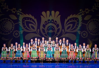 Na scenie chór w kostiumach łowickich podczas śpiewu