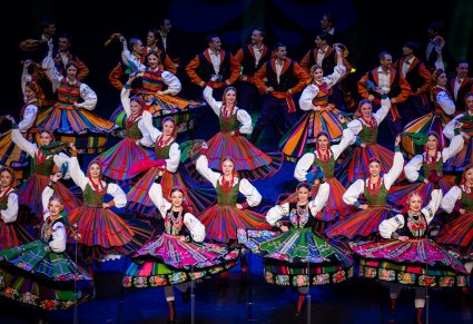 Artyści na scenie w kostiumach ludowych podczas wykonywania finałowej choreografii tanecznej