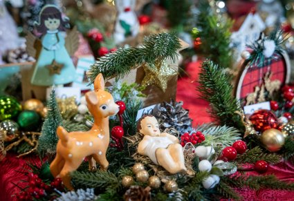 Zbliżenie na figurkę małego Jezuska w koło inne figurki z tematyki świątecznej