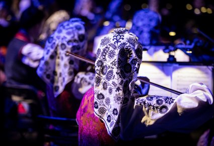 Muzyczka w trakcie gry na skrzypcach, widoczne nuty