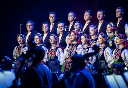 Zbliżenie na część Artystów Chóru w kostiumach łowickich ustawionych w rzędy