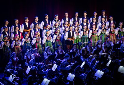 Część orkiestry, Solista a za nim ustawiony w rzędach Chór w kostiumach łowickich