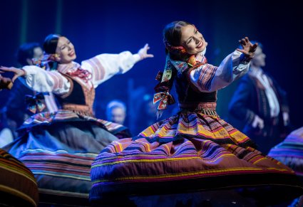 Zbliżenie na dwie Artystki w kostiumie krzczonowskim w trakcie obrotów na scenie