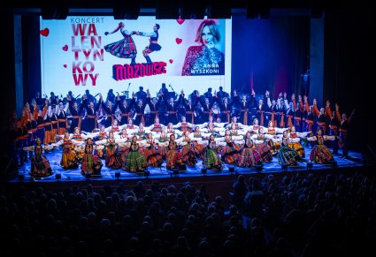 Artyści w kostiumach ludowych na scenie w choreografii finałowej koncertu