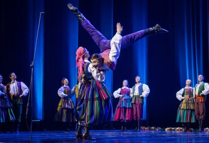 Para Artystów w kostiumach opoczyńskich na środku sceny w trakcie wykonywania figur tanecznych