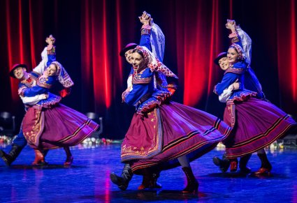 Trzy pary Artystów w kostiumach podegrodzkich w trakcie wykonywania choreografii tanecznej