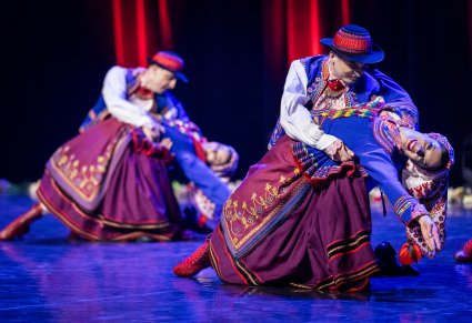 Dwie Pary Artystów w kostiumach podegrodzkich w trakcie wykonywania choreografii tanecznej