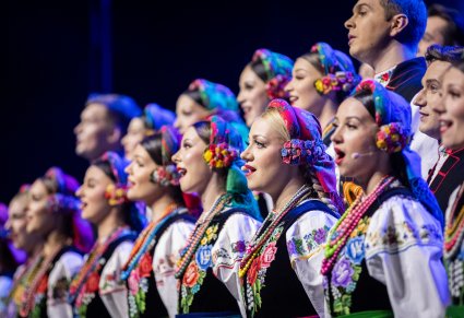 Zbliżenie na Artystów z chóru w kostiumach łowickich