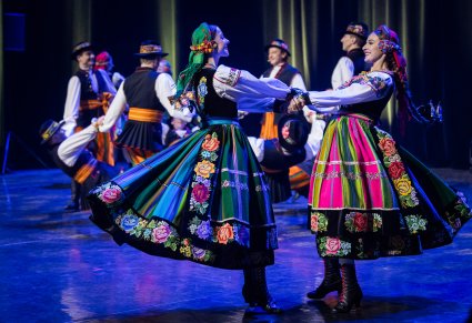 Zbliżenie na dwie Artystki w kostiumach łowickich wykonujące choreografię taneczną