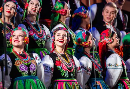 Zbliżenie na śpiewających Artystów w kostiumach łowickich