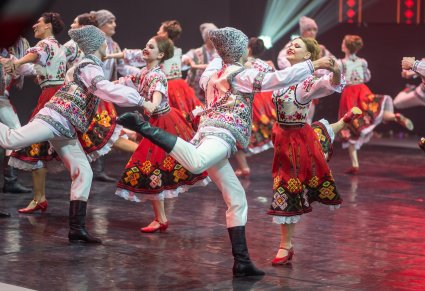 Pary Artystów z zespołu Baletul Național JOC w kostiumach ludowych podczas wykonywania choreografii tanecznej
