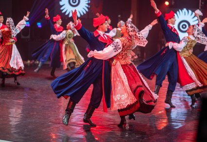 Pary Artystów w kostiumach wilanowskich w trakcie wykonywania choreografii tanecznej na scenie