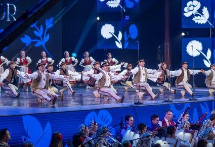 Na scenie Artyści w kostiumach jurgowskich wykonujący choreografię taneczną, widoczna część orkiestry obydwu zespołów