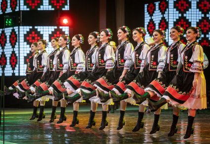 Artystki z zespołu Baletul Național JOC w kostiumach ludowych w trakcie wykonywania choreografii tanecznej