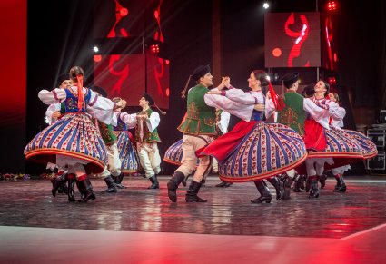 Pary Artystów z zespołu "Mazowsze" w kostiumach spiskich wykonujący choreografię taneczną na scenie