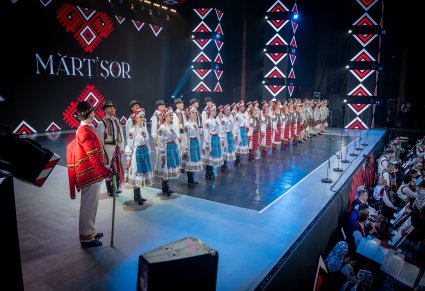 Artyści zespołu Baletul Național JOC w kostiumach ludowych ustawieni w dwóch rzędach na scenie