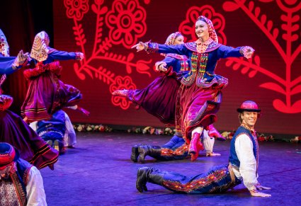 Artyści z zespołu "Mazowsze" w kostiumach podegrodzkich w trakcie wykonywania choreografii tanecznej