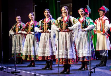 Artyści z zespołu "Mazowsze" w kostiumach krakowskich na scenie