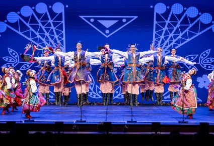 Artyści z zespołu "Mazowsze" w kostiumach krakowskich podczas wykonywania spektakularnych figur tanecznych