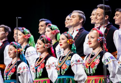 Zbliżenie na Artystów chóru w kostiumach łowickich z zespołu "Mazowsze"