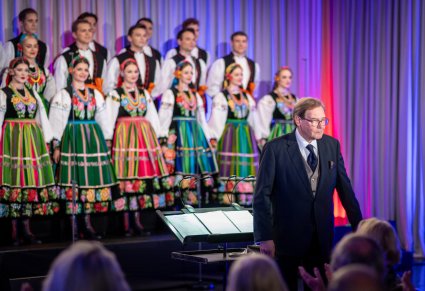 Zbliżenie na dyrygenta i chór podczas występu