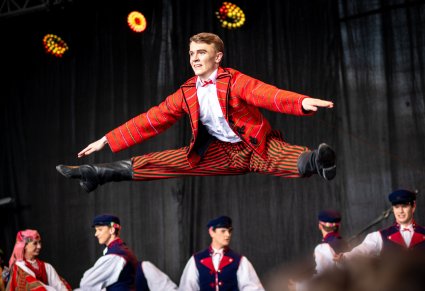 Zbliżenie na tancerza w kostiumie sieradzkim w akrobacji tanecznej