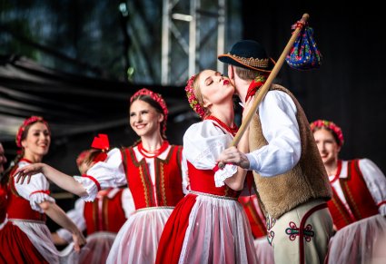 Zbliżenie na parę taneczną w kostiumach jurgowskich na scenie, w tle tancerki w kostiumach jurgowskich