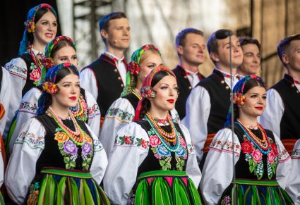 Zbliżenie na artystów chóru w kostiumach łowickich