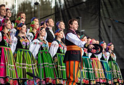 Zbliżenie na artystę chóru w trakcie wykonywania utworu, w tle chór "Mazowsza"