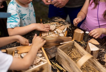 Młodzi uczestnicy budują domki dla owadów podczas warsztatu rękodzielniczego