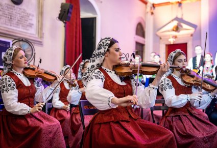 Zbliżenie na trzy Muzyczki grające na instrumentach smyczkowych