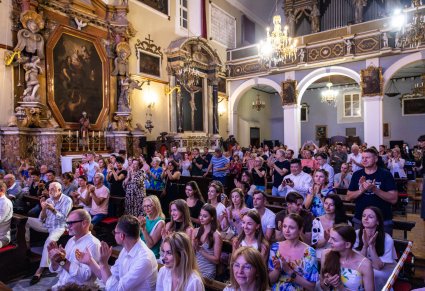 Widok na publiczność i pięknie zdobioną przestrzeń pomieszczenia