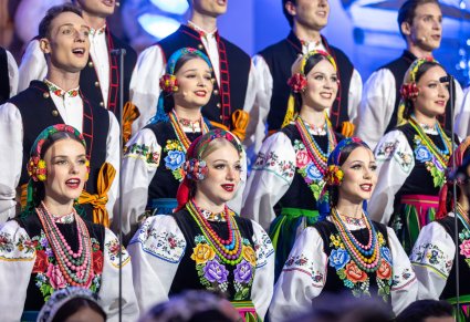 Zbliżenie na śpiewający chór w kostiumach łowickich