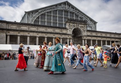 Artyści w kontuszach wraz gośćmy Polskiego Dnia w Brukseli wykonujący wspólną choreografię taneczną na placu