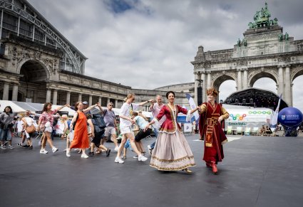 Artyści w kontuszach wraz z gośćmi Polskiego Dnia w Brukseli wykonują wspólną choreografię taneczną na placu