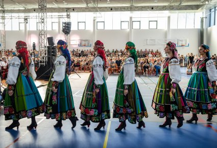 Artystki chóru w kostiumach łowickich wchodzące na scenę