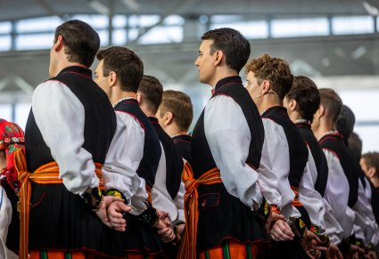 Zbliżenie na artystów chóru w kostiumach łowickich