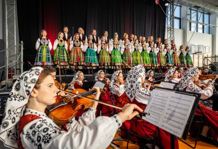 Orkiestra z widocznym chórem w tle podczas koncertu