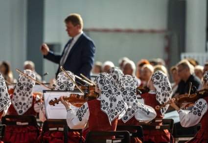 Orkiestra podczas koncertu, w tle widoczny dyrygent