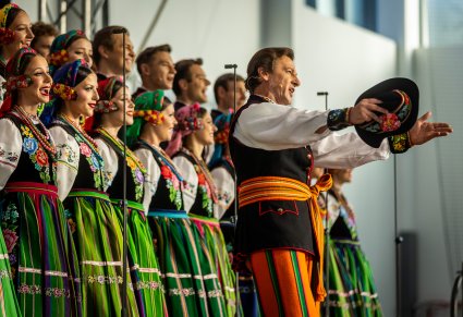 Solista chóru podczas występu na koncercie, w tle widoczny chór