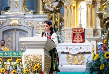 Artystka w kostiumie łowickim na mównicy podczas mszy