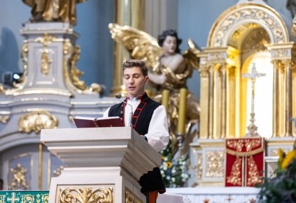 Artysta w kostiumie łowickim na mównicy podczas mszy