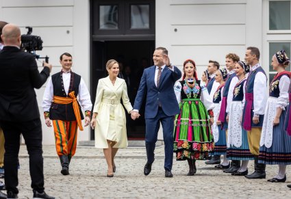 Para Prezydencka idąca w towarzystwie pary ubranej w kostiumy łowickie