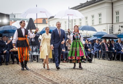 Para Prezydencka eskortowana na scenę przez parę w kostiumach łowickich