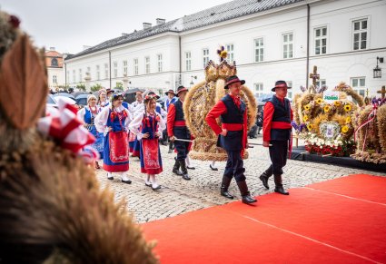 Zespół ludowy wnoszący zwycięski wieniec dożynkowy na scenę