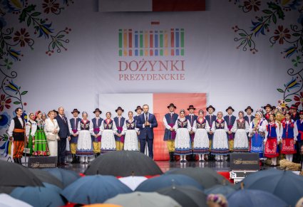 Przemawiający Prezydent na scenie, w tle zespół "Mazowsze"