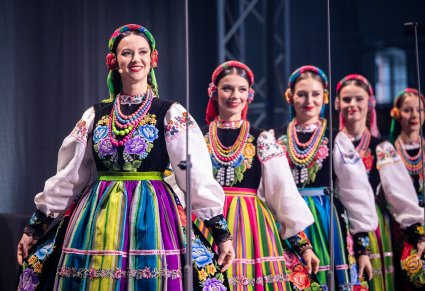 Artystki chóru w kostiumach łowickich wchodzące na scenę