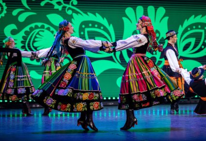 Zbliżenie na dwie Artystki w kostiumach łowickich podczas wykonywania choreografii tanecznej