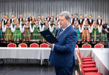 Dyrektor Jacek Boniecki przemawia na tle chóru